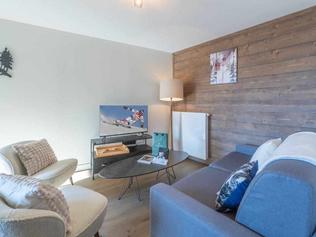 a living room with a blue couch and a table at Appartement Alpe d'Huez 4 adultes+2 enfants avec parking et WiFi - FR-1-645-66 in LʼHuez