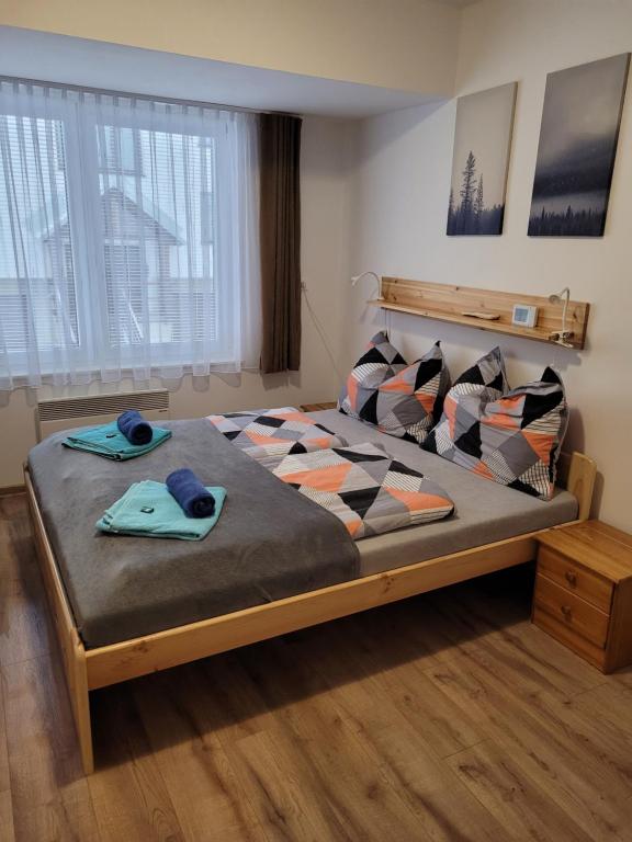 Un dormitorio con una cama grande con almohadas. en Apartmány 009, en Borová Lada