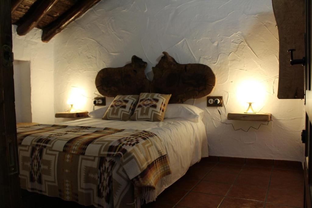 a bedroom with a large bed with two lamps at Cortijo Wenceslao II 