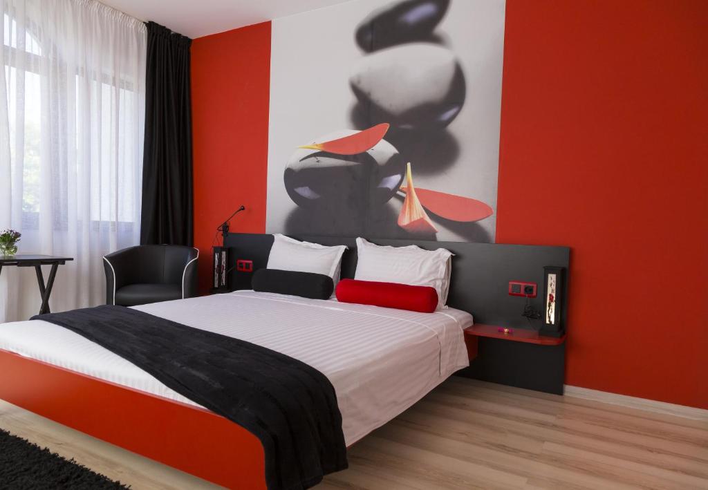 een slaapkamer met een bed en een rode muur bij Hotel GabriSa in Razgrad