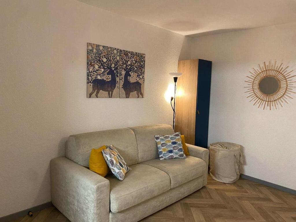 uma sala de estar com um sofá com almofadas em Studio Le Mont Beas em Aulus-les-Bains