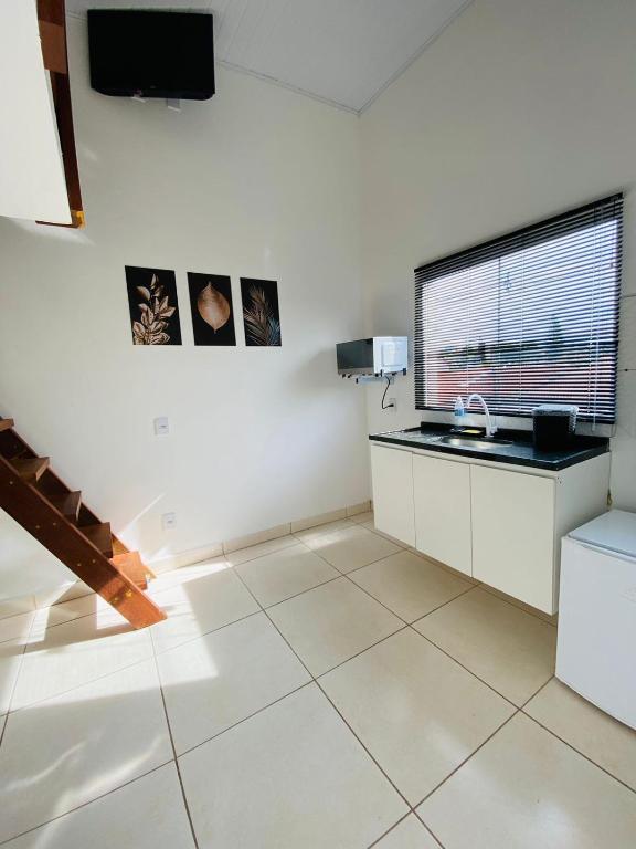 a kitchen with a sink and a tv on the wall at DuPai 12 Sorocaba in Sorocaba
