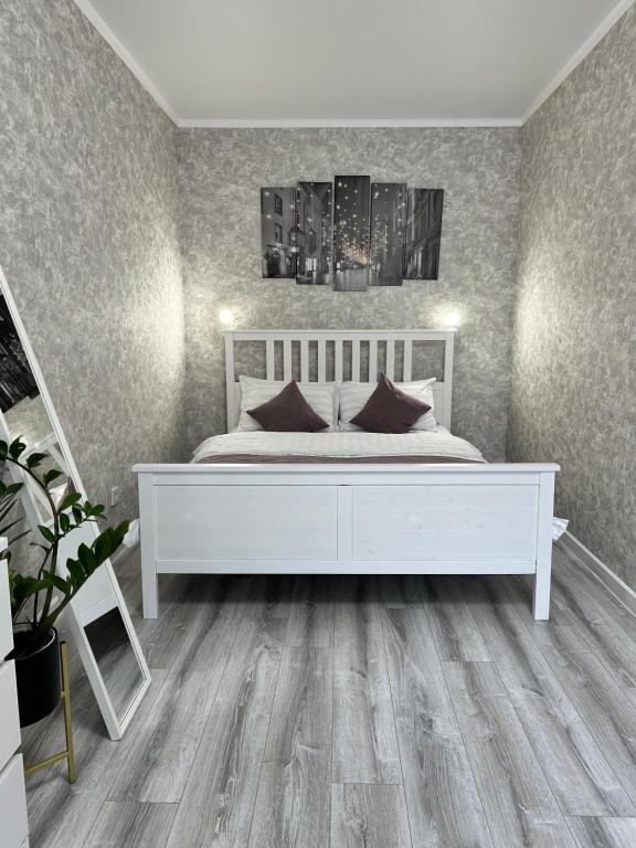 - une chambre avec un lit blanc et du parquet dans l'établissement Уютная квартира ЖК Сказочный мир город Астана, à Astana