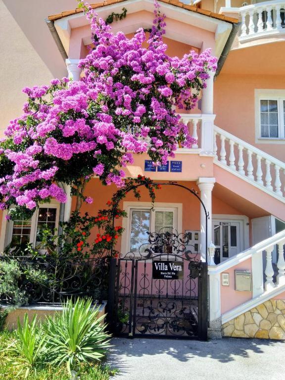 a building with purple flowers hanging over a gate at Hotel Villa Vera 2 in Fažana