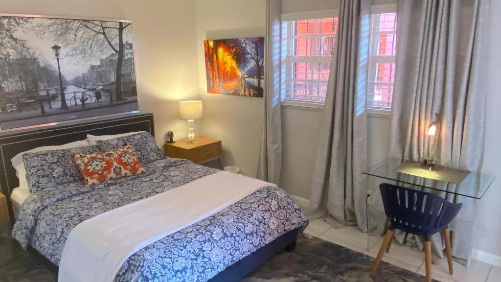 a bedroom with a bed and a chair and windows at Fort Lauderdale Room Rental in Fort Lauderdale