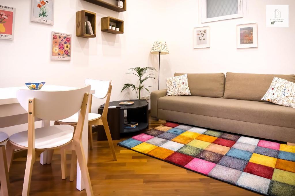 a living room with a couch and a colorful rug at Gli Appartamenti al Duomo in Catania