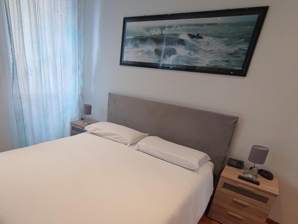 um quarto com uma cama e uma fotografia na parede em MARCO'S HOUSE em Sanremo