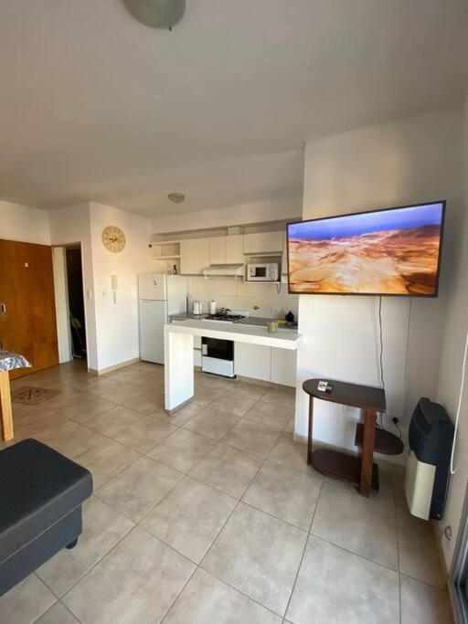 a kitchen with a large tv on the wall at Departamento céntrico completo in Bahía Blanca