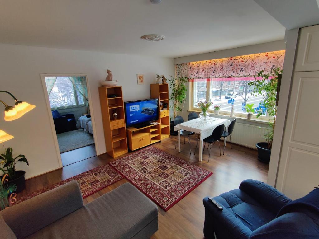 ein Wohnzimmer mit einem Sofa, einem Tisch und einem TV in der Unterkunft City Home Lahti in Lahti