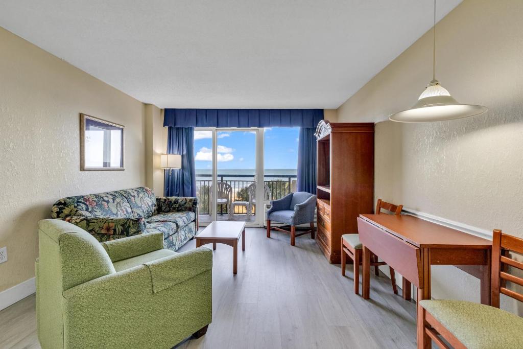 een woonkamer met een bank en een tafel bij Oceanfront Boardwalk Condo w Private Balcony and Beach in Myrtle Beach
