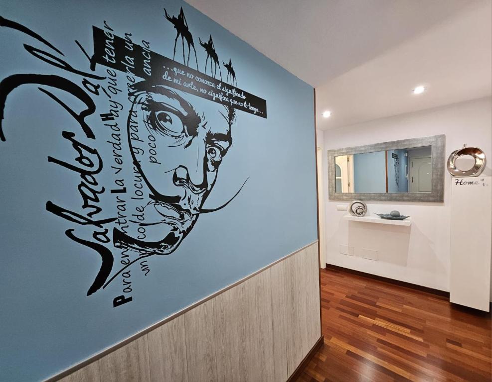 um corredor com um mural de parede de um homem em Apartamento Vilallonga em Figueres