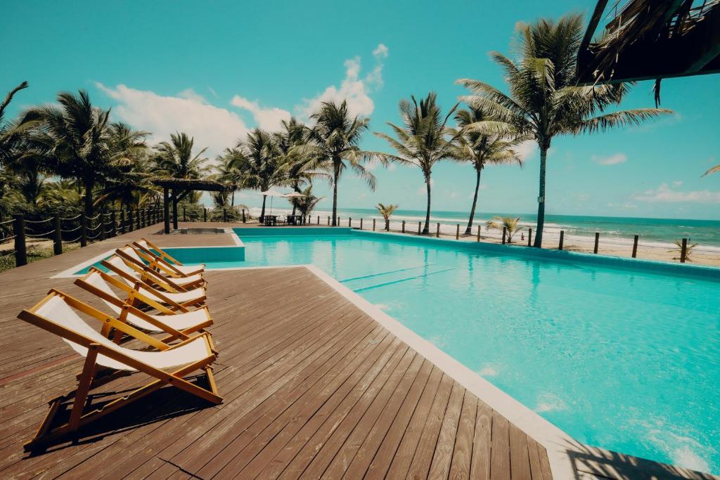 una piscina con 2 tumbonas junto a la playa en Vivant Eco Beach OFICIAL en Barra Grande