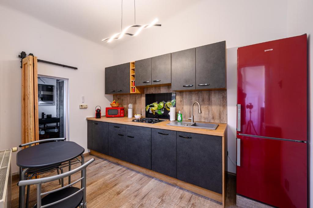 a kitchen with black cabinets and a red refrigerator at Top at Park, das luxuriöse Appartement mit Terrasse und Parkplatz im Zentrum von Graz in Graz
