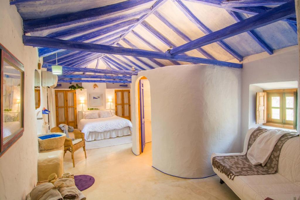 1 dormitorio con techos azules y 1 cama en una habitación en Casa Rural La Alameda, en Madridejos