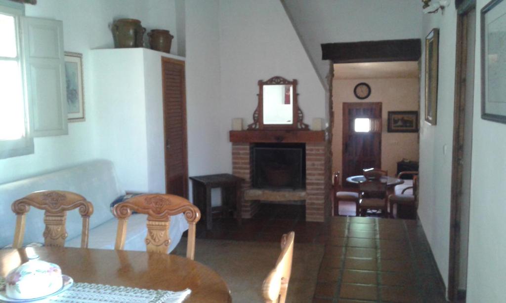 uma sala de jantar com uma mesa e cadeiras e uma lareira em Casa Rural en pleno paraje natural La Chirala em Enguera