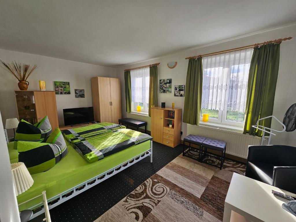 um quarto com uma cama verde num quarto em Ferienhaus und Straußwirtschaft im Weinberg em Freyburg