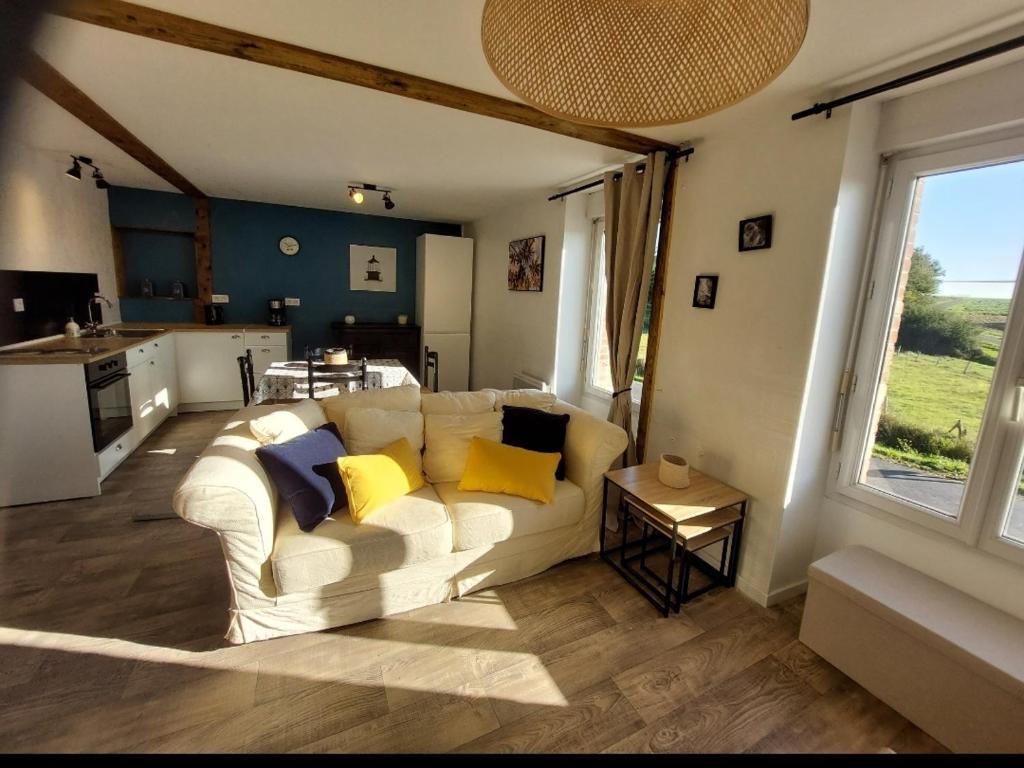 a living room with a white couch with yellow pillows at Gîte du moulin Mont Saint Michel in Pontorson