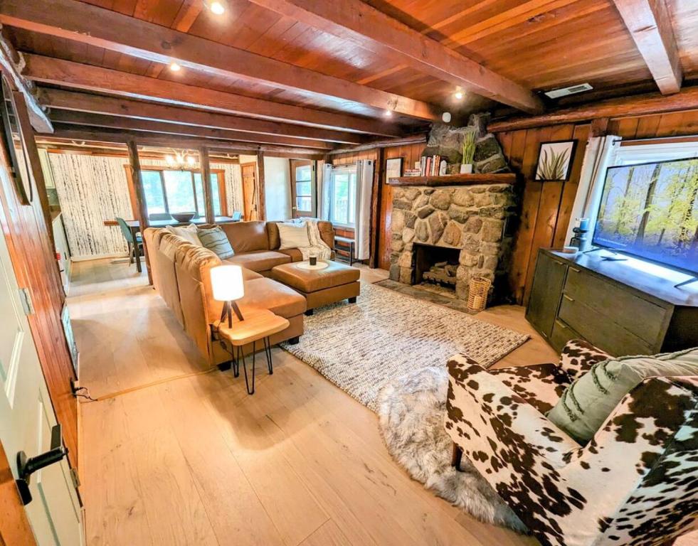 sala de estar con sofá y chimenea en Rustic Escape in Greenwood Lake en West Milford