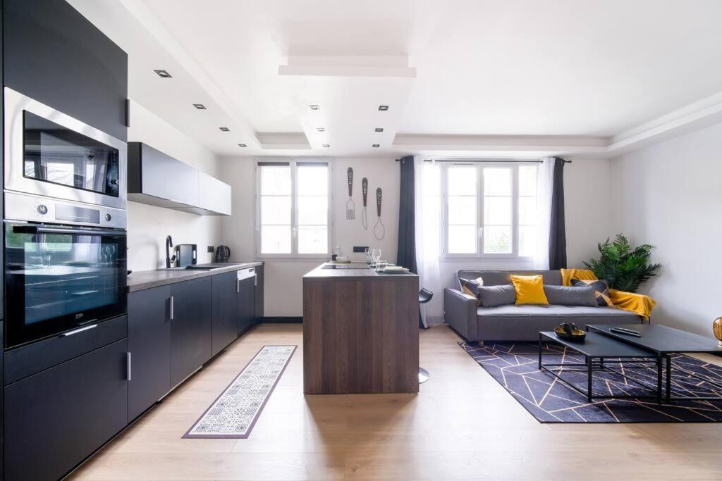 cocina y sala de estar con sofá y mesa en Le Black & White - 10 min Orly, 3 min gare Juvisy en Athis-Mons