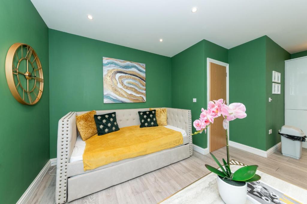 een woonkamer met groene muren en een bank bij Free Parking Guaranteed Weekly & Monthly Stay Savings Close to City Centre in Reading