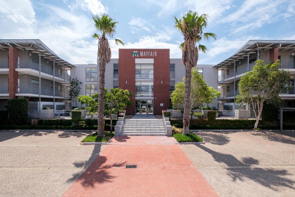 a building with palm trees in front of it at Belina - Mayfair Premier in Cape Town