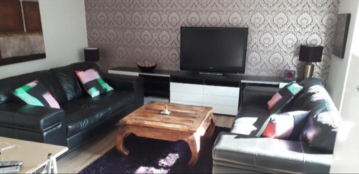 a living room with a couch and a coffee table at Spacious Modern Apartment in Glasgow