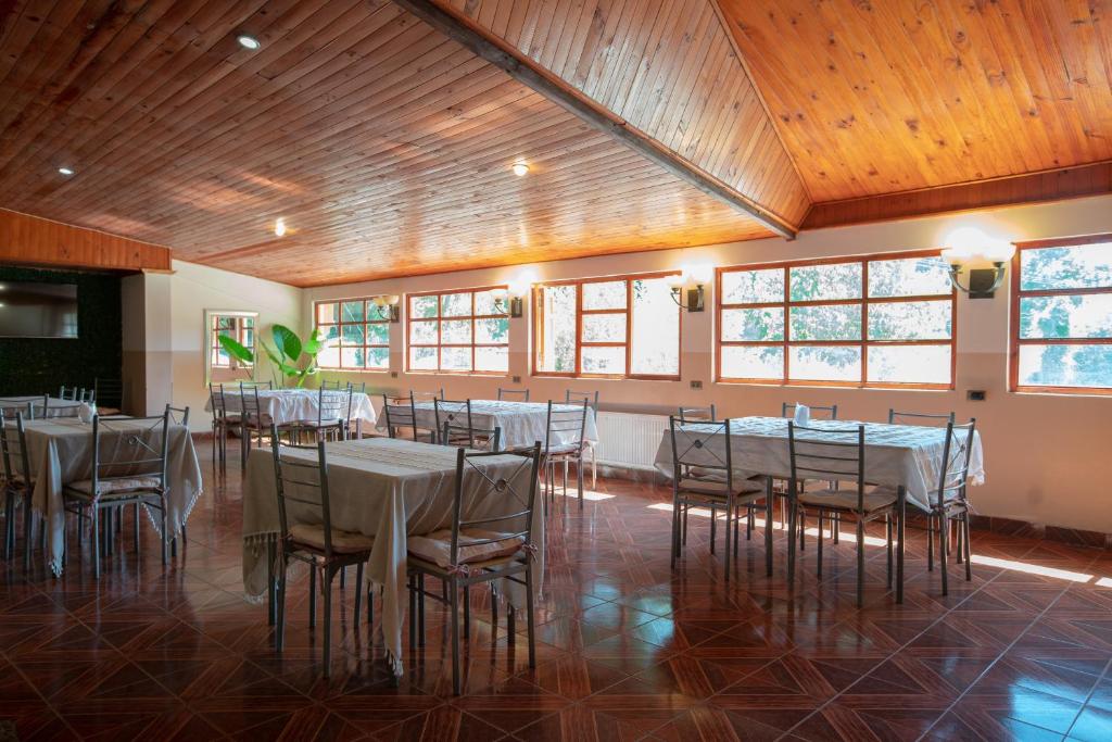 un salón de banquetes con mesas y sillas blancas en Hotel Linares, en Linares