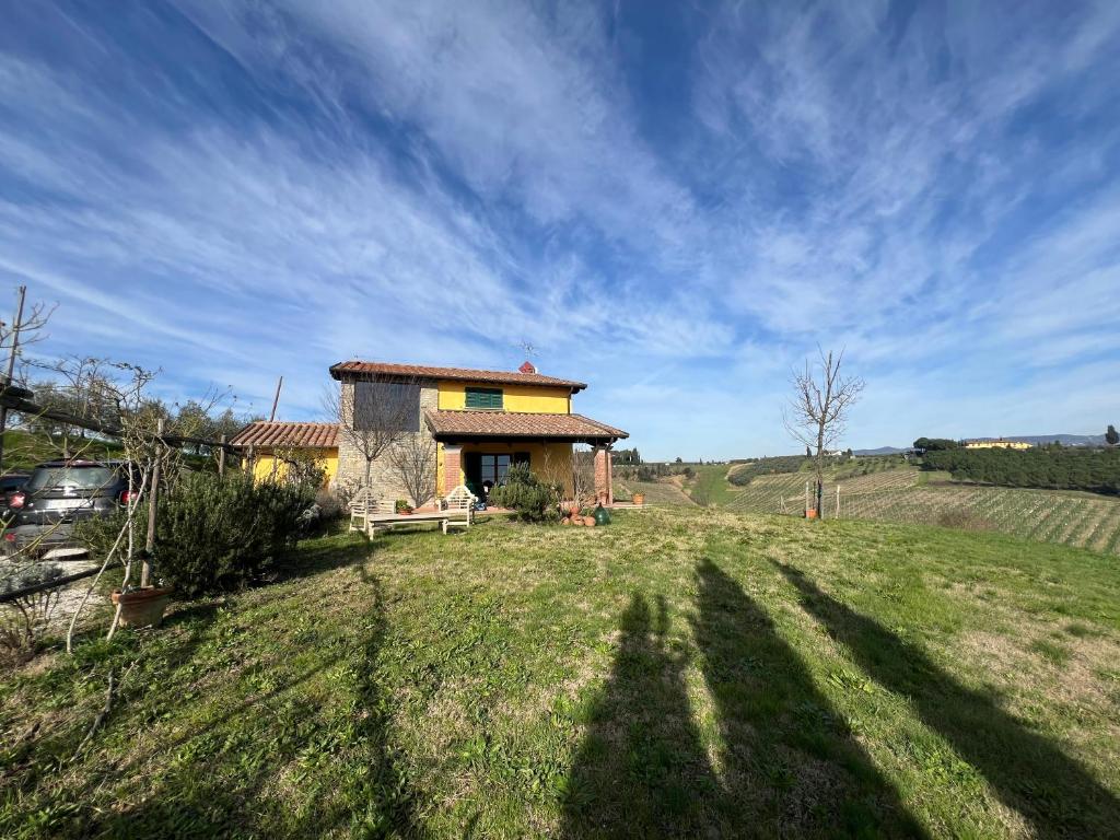 a small house on a hill with a grass field at Villa Cerretina in Cerreto Guidi