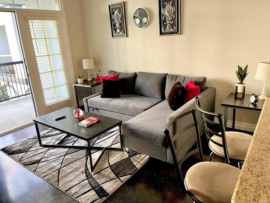 Luxe Lavish w/ Pool في هيوستن: غرفة معيشة مع أريكة وطاولة