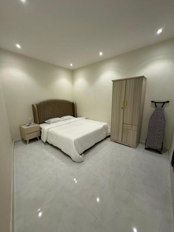 a bedroom with a bed and a cabinet in it at شقه فاخره الملز in Riyadh