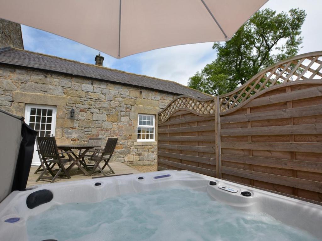 a hot tub in a backyard with an umbrella at 1 Bed in Rochester 49414 in Rochester