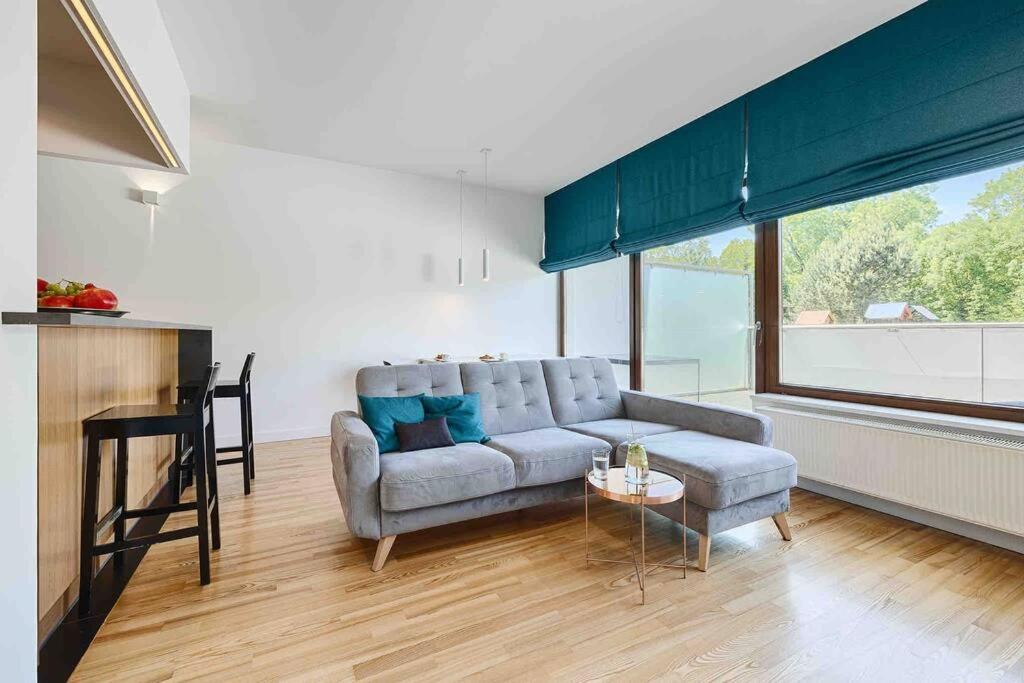 a living room with a couch and a table at Komfortowy apartament z siłownią i sauną Revisit Apartment 11 in Łódź