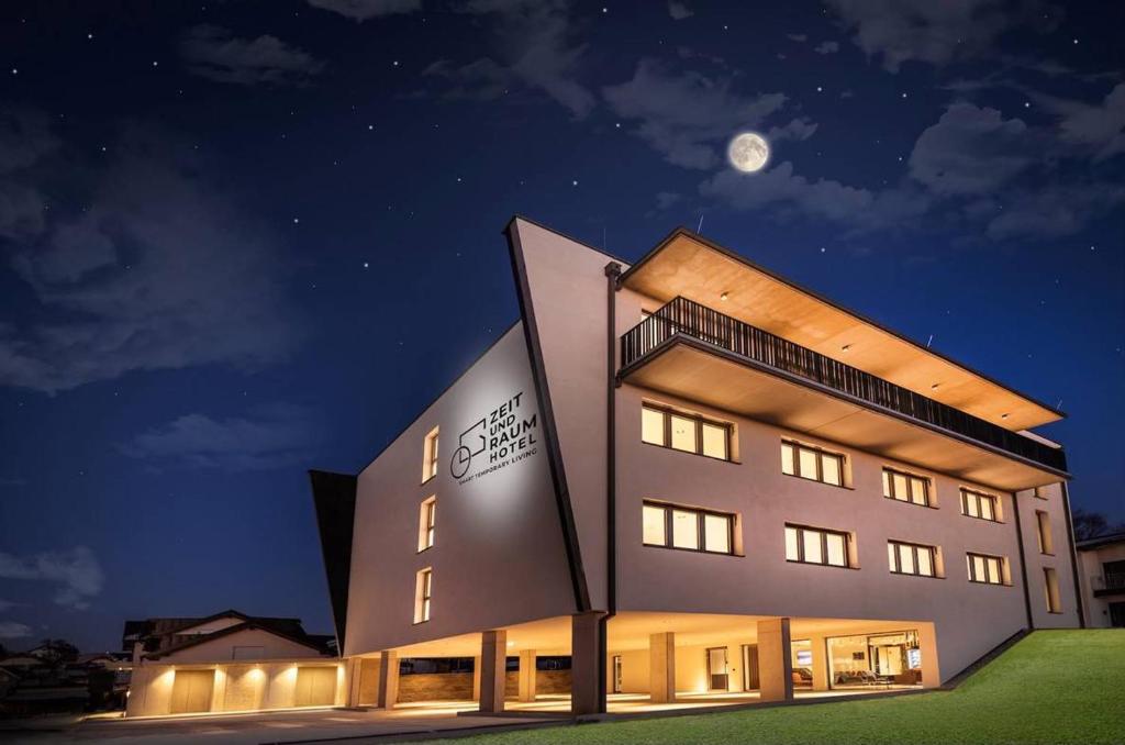 un gran edificio con una luna en el cielo en Zeit und Raum Hotel - Self Check-In en Eggelsberg