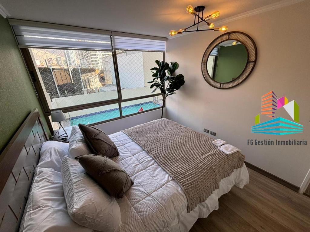 um quarto com uma cama, um espelho e uma janela em NUEVO E IMPECABLE A PASOS DEL MAR em Antofagasta