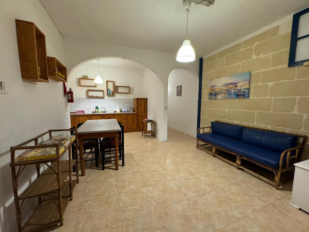 een woonkamer met een blauwe bank en een tafel bij Paradise 1 in Żebbuġ