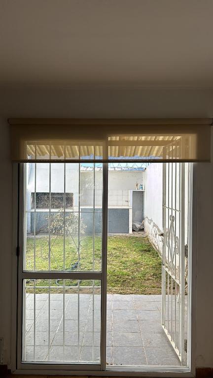 een glazen schuifdeur met uitzicht op een tuin bij Duplex 2 Dormitorios Neuquén in Neuquén