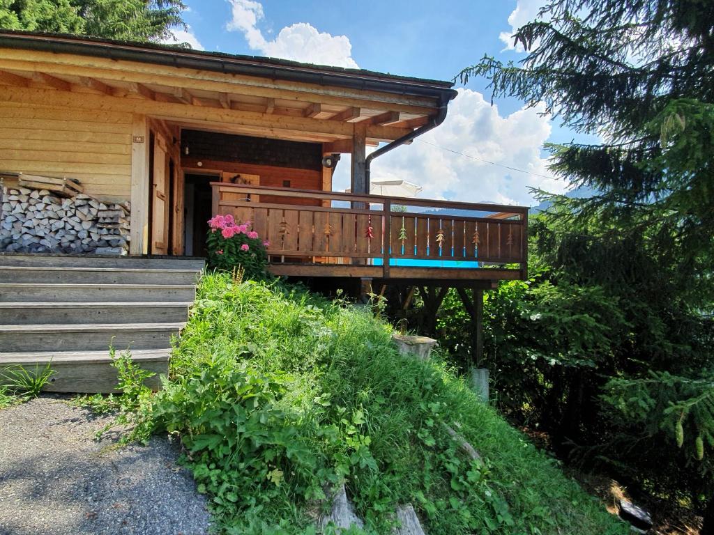 a house with a porch and stairs in front of it at Chalet Le Sapin in Le Grand-Bornand
