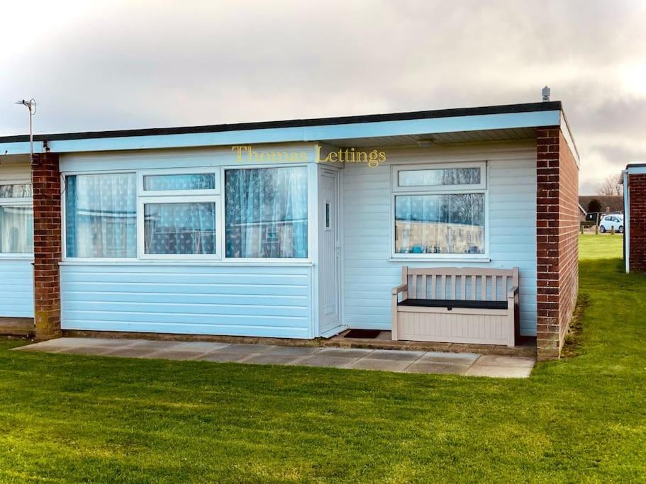 a blue building with a bench in front of it at Cosy 2 Bed Chalet in Great Yarmouth