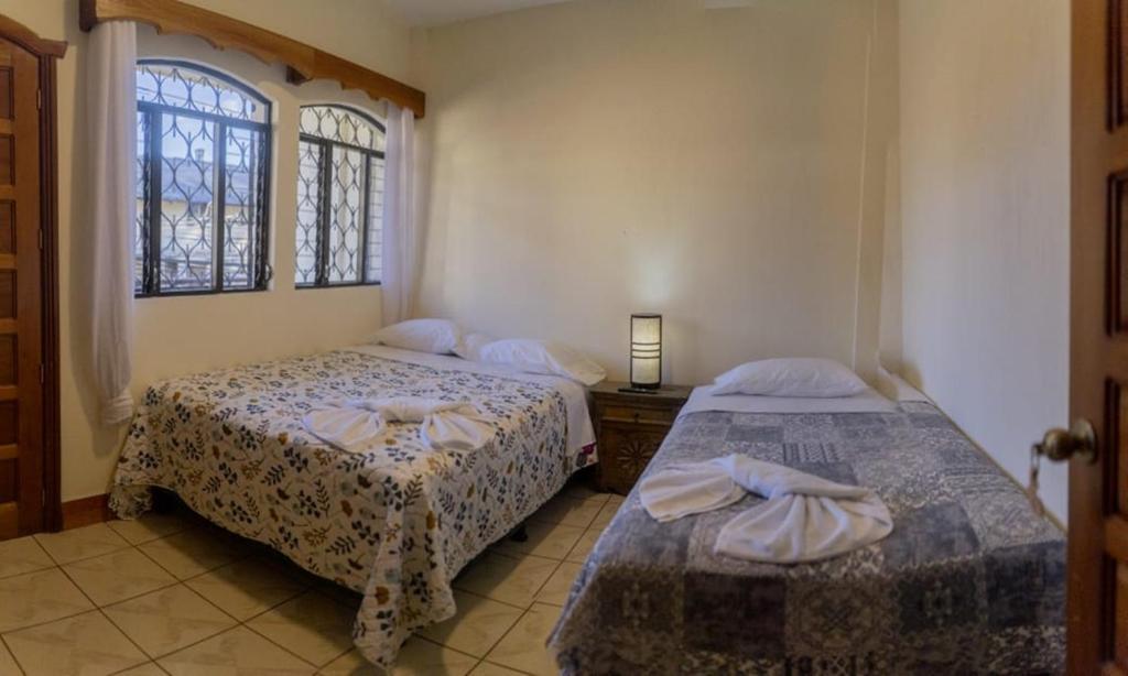 a bedroom with two beds and a window at Hotel Los Manantiales in Panajachel