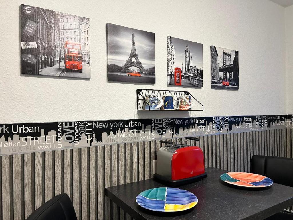 a table with plates on it with pictures on the wall at Gemütliches helles Apartment im Zentrum von Bayreuth in Bayreuth