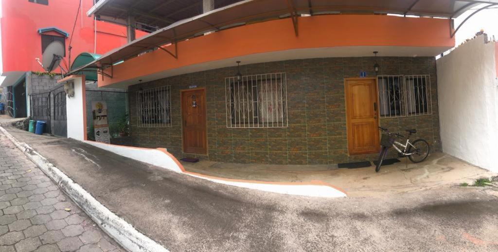 una bicicletta parcheggiata di fronte a un edificio di Casa de Huespedes Milena a Puerto Baquerizo Moreno