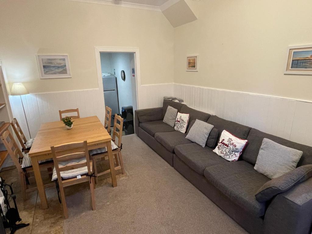 a living room with a couch and a table at 4 bedroom townhouse Kirkcudbright in Kirkcudbright