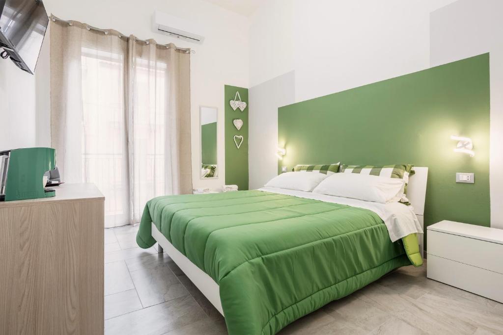 una camera da letto verde con un letto e una televisione di Case Billeci Casa Verde a Palermo
