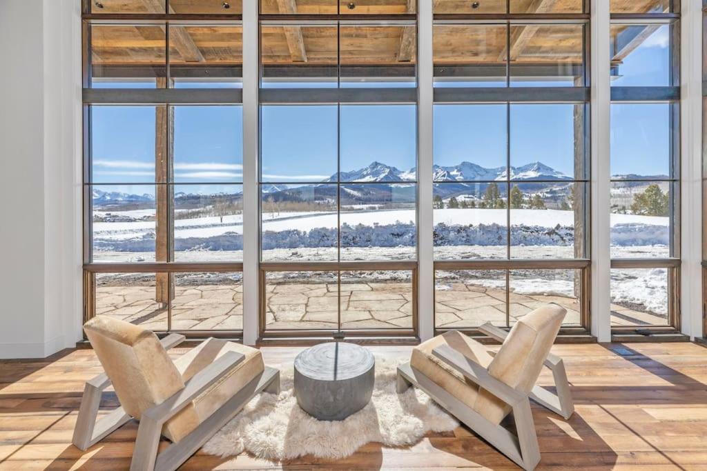 2 Stühle und ein Tisch in einem Zimmer mit einem großen Fenster in der Unterkunft Silverpick Ranch - adventure & luxury in Telluride in Telluride