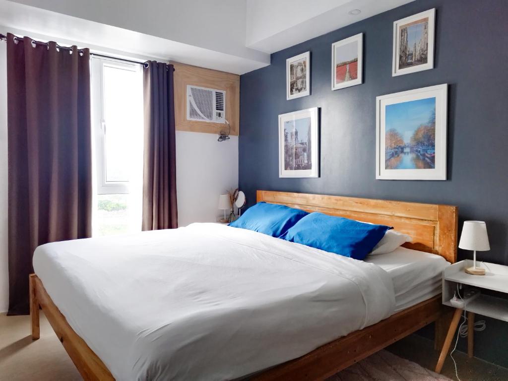 1 dormitorio con 1 cama grande y paredes azules en Modern Oasis*Heart of City*Fast Wi-Fi/Netflix WFH en Iloílo