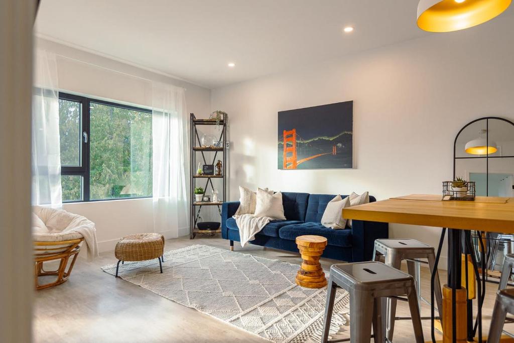 sala de estar con sofá azul y mesa en Revelstoke Alpine Retreat - RARE One-Bedroom Condo, en Revelstoke