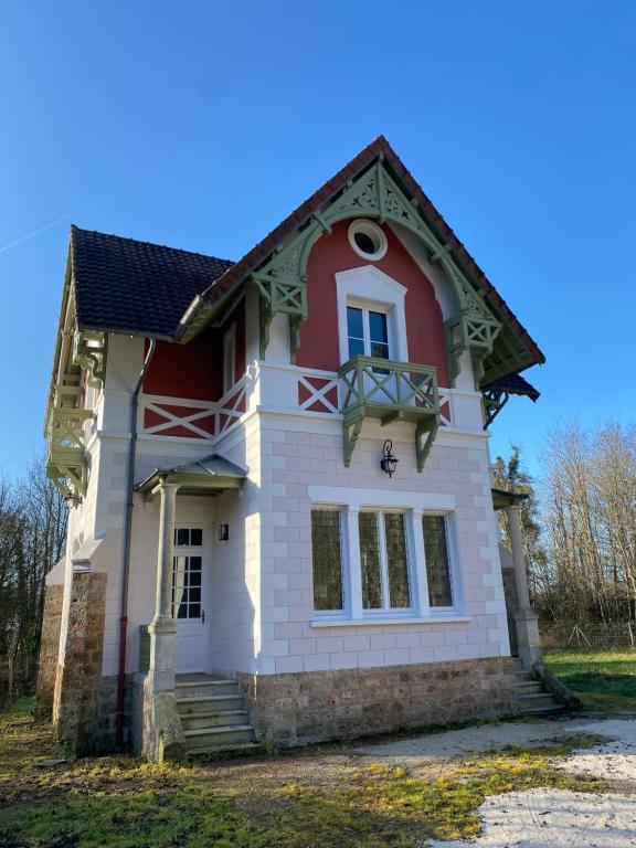 une maison avec un rouge et un blanc dans l'établissement le Pavillon d'Hermières, proche Disneyland Paris, à Favières