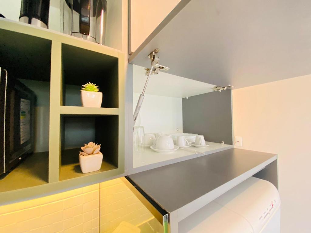 una cocina con dos macetas en los estantes en Ocean Porto Flats, en Porto de Galinhas