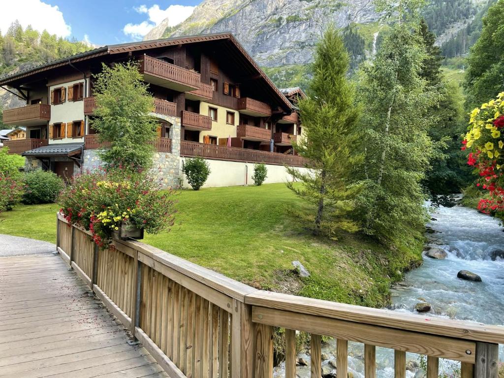 ein Hotel mit einer Brücke über einen Fluss und einen Berg in der Unterkunft Appartement de 2 chambres a Pralognan la Vanoise a 900 m des pistes avec balcon amenage et wifi in Pralognan-la-Vanoise