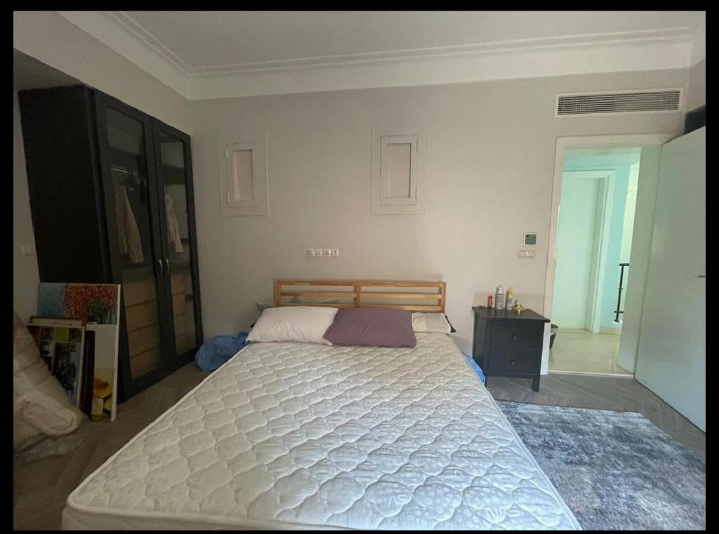 um quarto com uma grande cama branca em shebin em Shibīn al Kawm